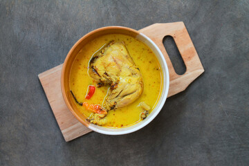 Top view of famous Indonesian chicken curry, served in a bowl. Isolated on gray table.