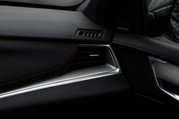 A black car interior with a vent on the dashboard
