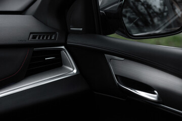 A car interior with a black dashboard and a silver steering wheel