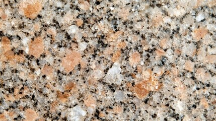 A textured surface of granite featuring a mix of beige, black, and white speckles, ideal for countertops and decorative purposes.