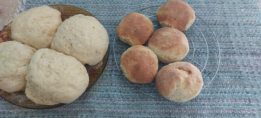 Homemade baked buns on a cooling rack on a gray background