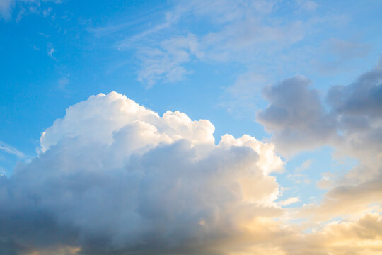 Fluffy white clouds floating in a bright blue sky during a calm afternoon