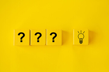 Question mark and lightbulb on wooden block; Problem and solution concept