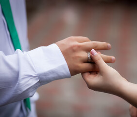The bride places a gold wedding ring on the groom's finger. Traditional ceremony of exchanging wedding rings.