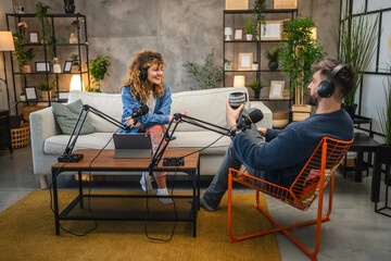 female guests with headphones answer on questions to male presenter
