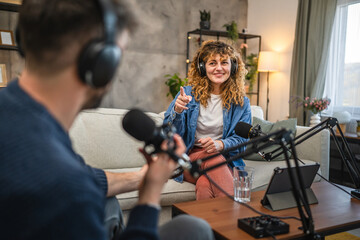 female guests with headphones answer on questions to male presenter