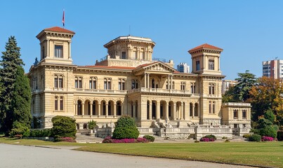 Obraz premium Grand mansion exterior with gardens, clear sky, urban backdrop, ideal for architecture or travel content