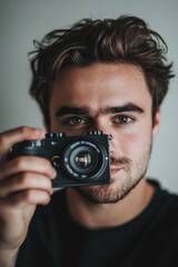 Fototapeta premium A young man taking a selfie with his camera, evoking a modern and stylish mood.