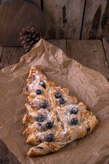Puff pastry baking in the shape of a Christmas tree with blueberries and cream
