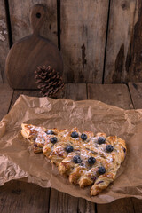 Puff pastry baking in the shape of a Christmas tree with blueberries and cream
