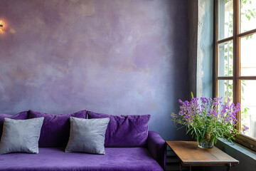 Lilac color accent in modern interior. Comfortable couch and table with flowers in living room.