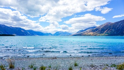 Stunning view of Lake Aohau surrounded by mountains and vibrant blue skies in New Zealand