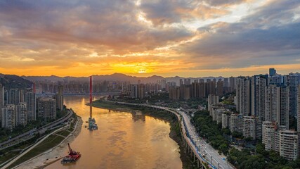 Fototapeta premium Sunset illuminates the confluence of two rivers in Chongqing with vibrant colors and stunning urban landscape