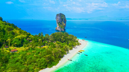 Top aerial drone view of a paradise beach, crystal clear turquoise ocean, cliff, white sand, and longtail boats in Thailand. Ko Poda island from above. © Alona