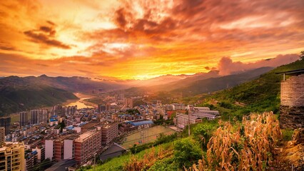 Fototapeta premium Vibrant fall sunset over the city with fiery clouds illuminating the evening sky