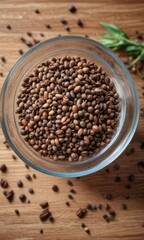 A glass bowl filled with a handful of whole chai seeds on a wooden table, spices, tea substitute, chai seeds