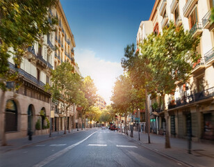 outdoors in a barcelona street the blurred image showcases a casual bokeh ambiance with defocused trees and buildings under a clear european sky