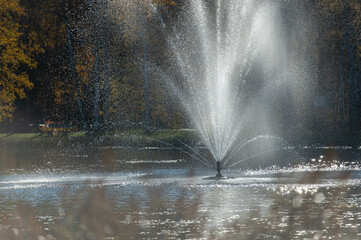 Water fountain in the park illuminated by the evening sun in Vecpiebalga, Latvia