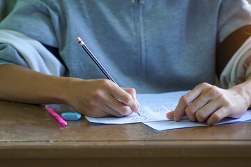Asian students are taking exams to measure learning in the classroom. Soft and selective focus.