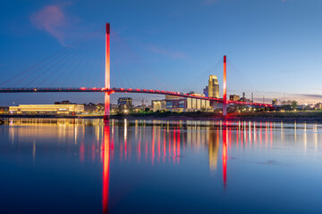 Omaha, Nebraska, USA downtown city skyline and pedestrian bridge at night.