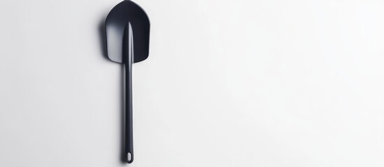 Obraz premium Black spatula on a white background with copy space for text or branding elements