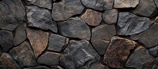 Obraz premium Dark Faceted Stone Wall with Varied Textures and Shadows, Ideal for Text Overlay or Background Design