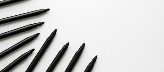 Scattered black felt tip markers arranged diagonally on a clean white background with ample empty space for creative text placement.