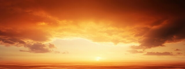 Fototapeta premium Sunset with dramatic clouds over the ocean creating a warm orange and yellow gradient sky with Copy Space for text insertion