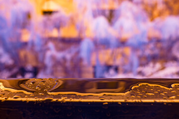 Infrared photography, a close-up view of a surface with water droplets on it, set against a blurred, colorful background