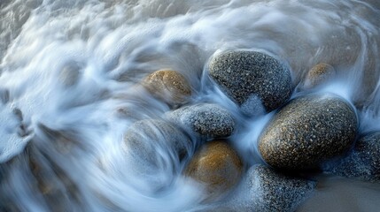 Gentle waves washing over smooth pebbles on the shore creating a serene coastal atmosphere with ample Copy Space for text placement.