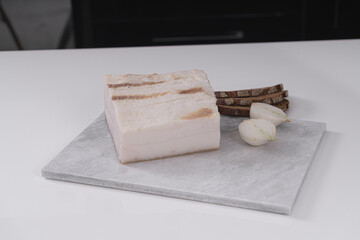 Homemade lard piece on marble light board on white table