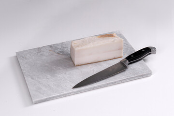 Homemade lard piece on marble light board on white table