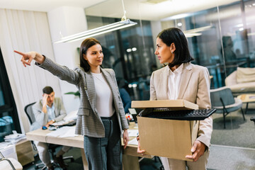 Businesswoman got fired from her job. Taking box with her personal stuff from the office.