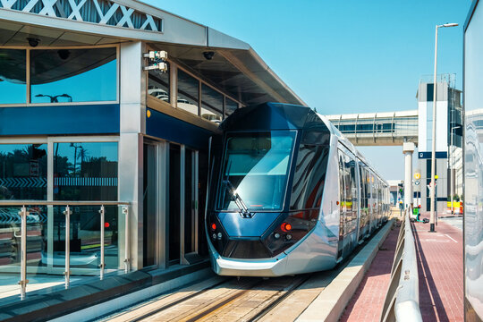 Dubai tram on elevated track passing through modern skyscrapers and modern architecture. Traffic on street and futuristic transport infrastructure in Dubai city, United Arab Emirates