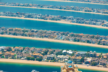Aerial view of luxury villas on The Palm Jumeirah artificial island with sandy beach and turquoise waters of Arabian Gulf n Dubai city, United Arab Emirates