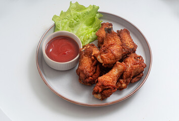 Fried baked chicken wings with tomato sauce