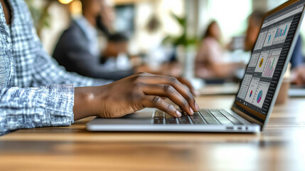 African female adult analyzing data on laptop in office environment