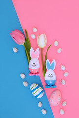 Easter bunny abstract with spring tulip flowers and eggs on pink blue diagonal background. Symbols for holiday season.