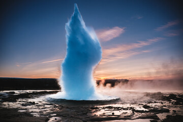 Strokkur Geysir eruption at sunset in south Iceland, Haukadalur valley