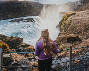Traveler admiring the powerful Gullfoss waterfall in south Iceland's Golden Circle...
