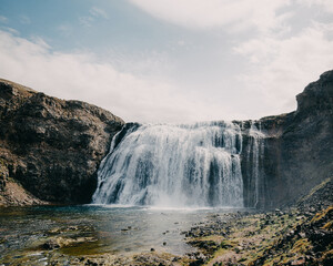 Obraz premium Þórufoss waterfall cascading over rugged cliffs in south Iceland under a bright sky...