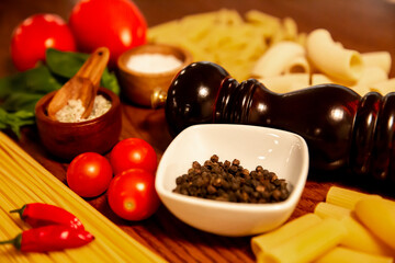 Bodegón compuesto por vegetales, pasta, sal, pimienta y guindilla