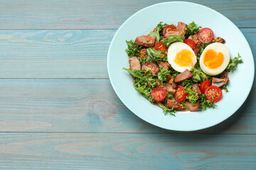 Delicious fresh tuna salad on light blue wooden table, top view. Space for text