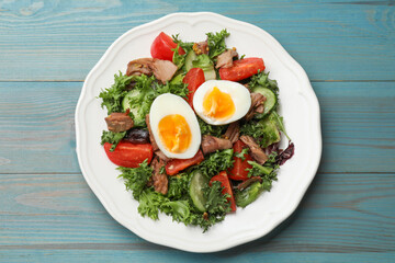 Delicious fresh tuna salad on light blue wooden table, top view