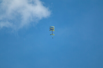 Group of skydivers performing synchronized aerobatics with yellow-blue Ukrainian parachutes in a...