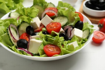 Delicious fresh Greek salad on white table, closeup