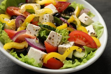 Delicious fresh Greek salad in bowl on table, closeup