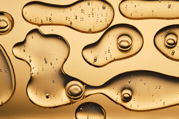 The beautiful texture of the cosmetic serum on a gold background that takes up most of the photo.