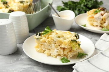 Tasty pasta casserole with cheese and broccoli served on grey table, closeup