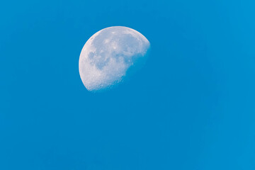 Detailed megazoom (600mm) summer view of the moon with craters during daytime with blue sky at Mount Ahorn, Mayrhofen, Zillertal valley, Schwaz, Tyrol, Austria